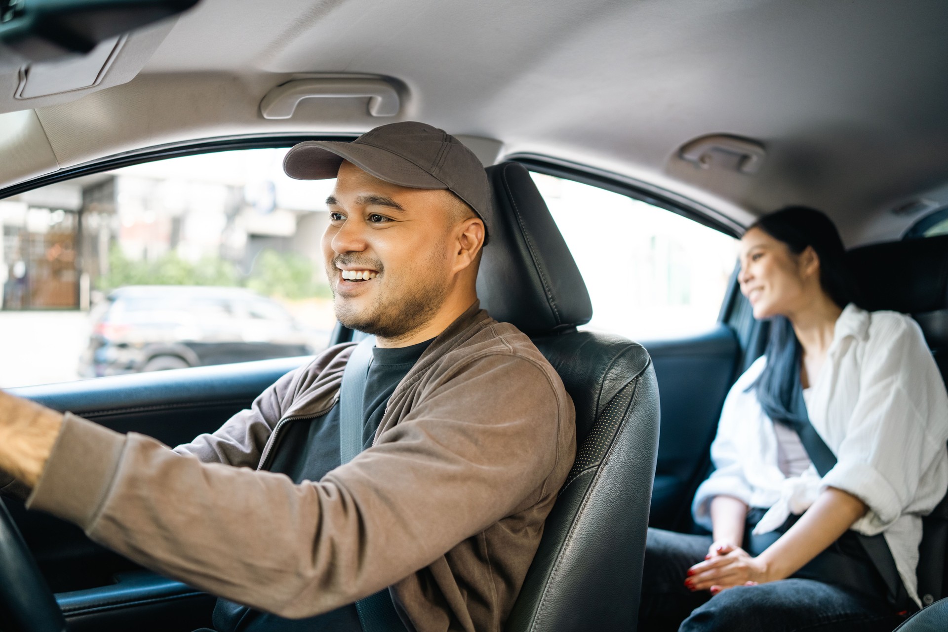 Young asian woman traveling in the downtown city with taxi driver service. Female passenger sitting in backseat calling taxi driver by application.